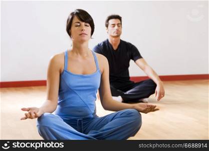 health club: man and women doing yoga.
