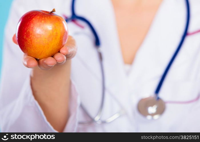 Health concept. Closeup nutritionist doctor holding apple fruit in her hand. Dietitian recommending healthy food. Diet.