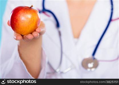 Health concept. Closeup nutritionist doctor holding apple fruit in her hand. Dietitian recommending healthy food. Diet.