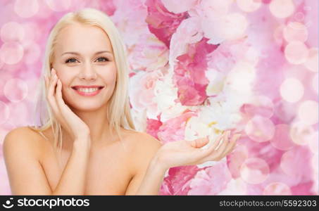 health, cosmetics, advertising and beauty concept - smiling woman holding imaginary lotion jar and applying it