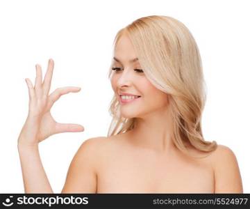 health, cosmetics, advertising and beauty concept - smiling woman holding something imaginary