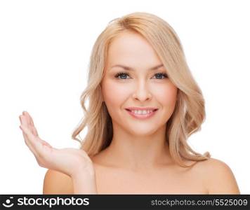 health, cosmetics, advertising and beauty concept - smiling woman holding something imaginary