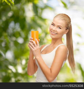 health, diet and food concept - young woman holding glass of orange juice