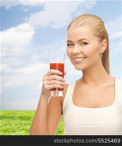 health, diet and food concept - young woman holding glass of tomato juice