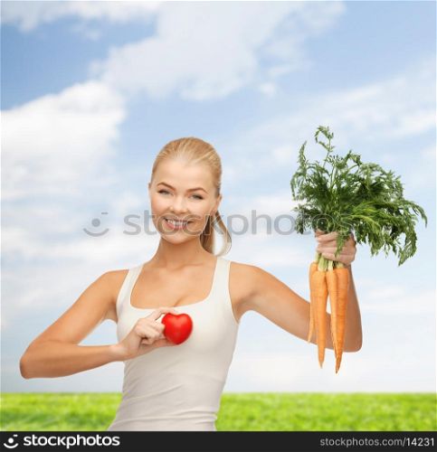 health, diet and food concept - young woman holding heart symbol and carrots