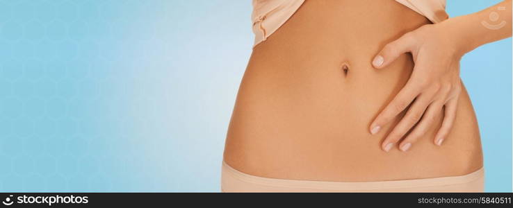 health, digestion, beauty, people and weigh loss concept - close up of woman pointing finger to belly over blue background