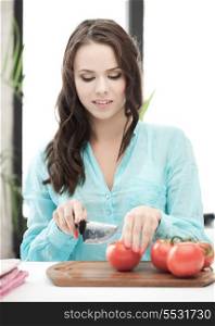 health, food and nutrition concept - beautiful woman in the kitchen cutting vegetables