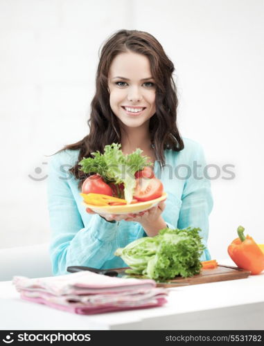 health, food and nutrition concept - beautiful woman in the kitchen cutting vegetables