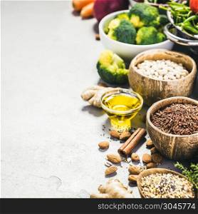 Health food concept with legumes, grains, seeds and organic vegetables on grey concrete background, Copyspace