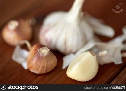 health, food, cooking, traditional medicine and ethnoscience concept - close up of garlic on wooden table