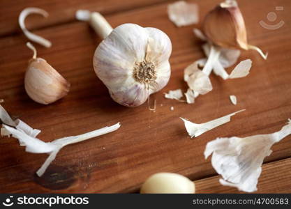 health, food, cooking, traditional medicine and ethnoscience concept - close up of garlic on wooden table