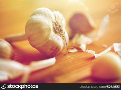 health, food, cooking, traditional medicine and ethnoscience concept - close up of garlic on wooden table. close up of garlic on wooden table