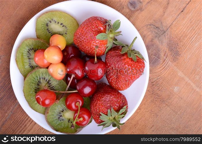 health fruit with cherry, strawberry, kiwi on wooden plate