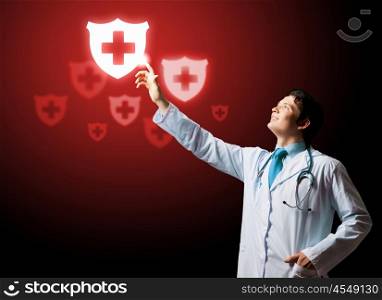 Health guard. Young doctor touching with finger media medical sign