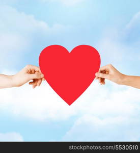 health, love and relationships concept - closeup of couple hands with big red heart