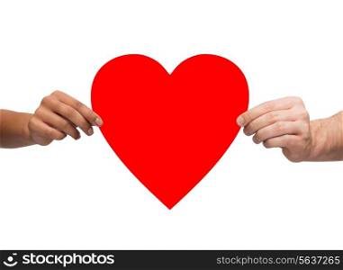 health, love and relationships concept - closeup of multiracial couple hands with big red heart