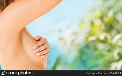 health, medicine and beauty concept - woman checking breast for signs of cancer