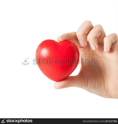 health, medicine and charity concept - close up of female hands with small red heart