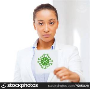 health, medicine and pandemic concept - african american female doctor holding coronavirus sign. african american doctor with coronavirus sign