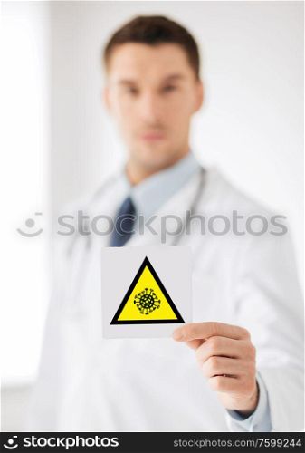 health, medicine and pandemic concept - male doctor holding coronavirus sign. male doctor holding coronavirus caution sign