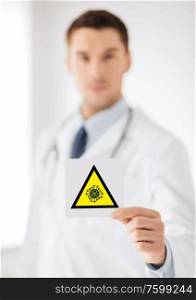 health, medicine and pandemic concept - male doctor holding coronavirus sign. male doctor holding coronavirus caution sign