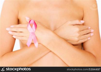 health, medicine, beauty concept - naked woman with breast cancer awareness ribbon