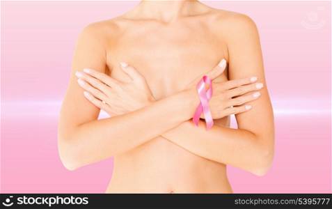 health, medicine, beauty concept - naked woman with breast cancer awareness ribbon