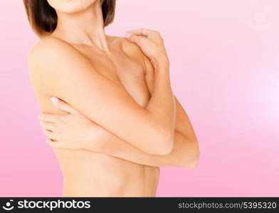 health, medicine, beauty concept - topless woman with perfect skin and hands over breast