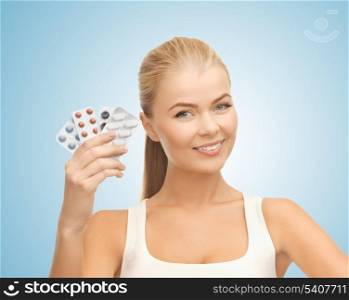 health, medicine, beauty concept - young woman with variety of pills