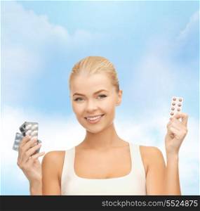 health, medicine, diet and pharmacy concept - young woman with variety of pills