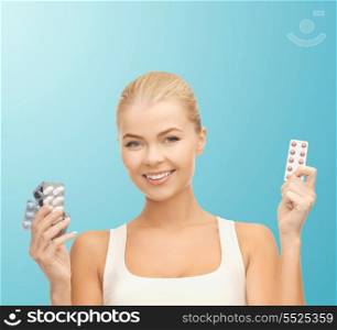 health, medicine, diet and pharmacy concept - young woman with variety of pills