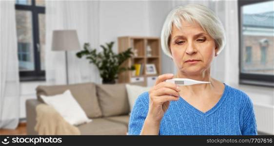 health, old age and people concept - sick senior woman with thermometer over home living room background. sick senior woman with thermometer