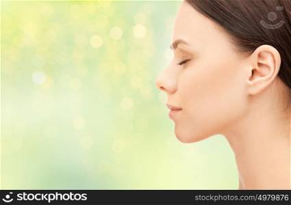 health, people and beauty concept - beautiful young woman face over green background. beautiful young woman face over green background