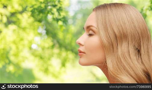 health, people and beauty concept - beautiful young woman face over green natural background. beautiful young woman face over natural background