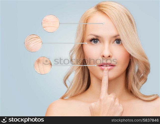 health, people and beauty concept - beautiful young woman touching her lips over blue background