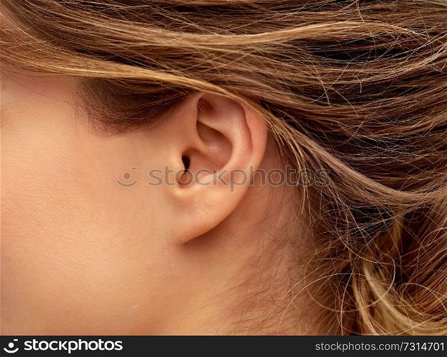 health, people and beauty concept - close up of young woman face from ear side. close up of young woman face from ear side