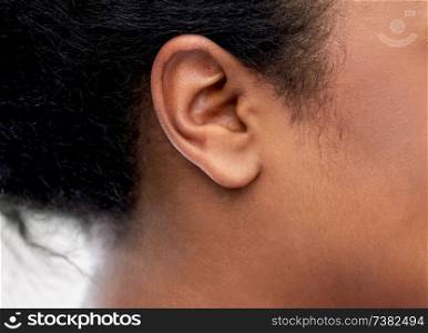 health, people and hearing concept - close up of young african american woman ear. close up of young woman ear