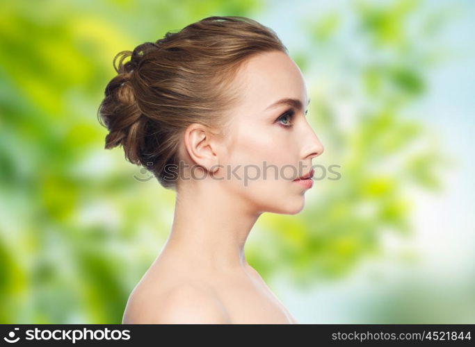 health, people, eco and beauty concept - beautiful young woman face over green natural background