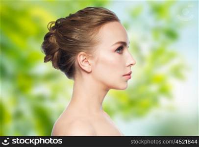 health, people, eco and beauty concept - beautiful young woman face over green natural background