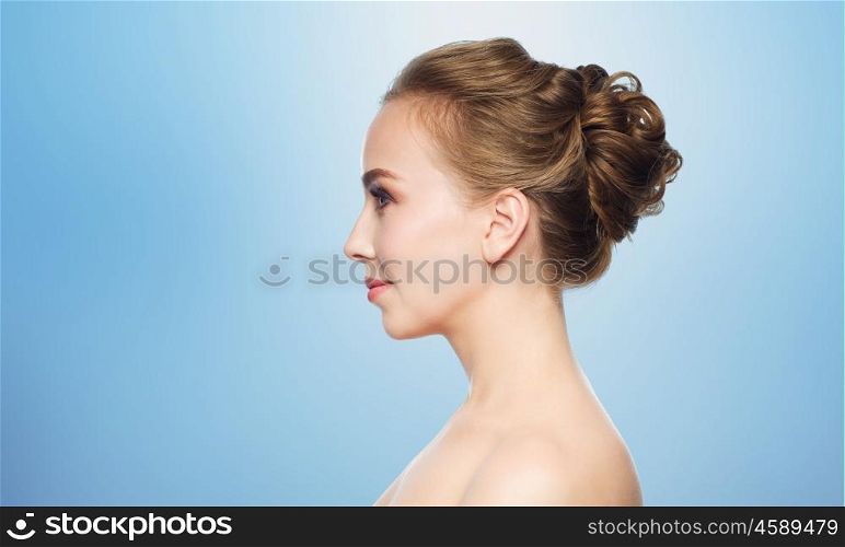 health, people, plastic surgery and beauty concept - beautiful young woman face over blue background