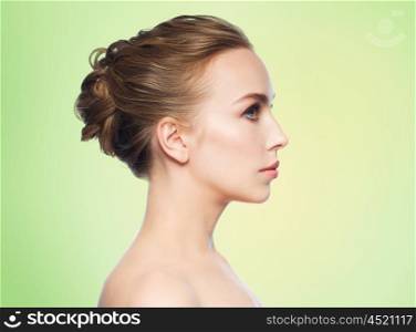 health, people, plastic surgery and beauty concept - beautiful young woman face over green background