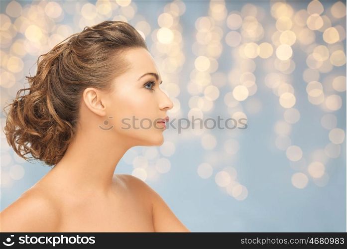 health, people, plastic surgery, holidays and beauty concept - beautiful young woman face over lights background