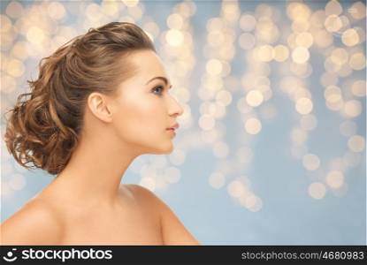 health, people, plastic surgery, holidays and beauty concept - beautiful young woman face over lights background