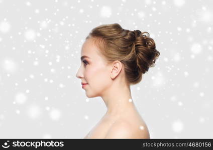 health, people, winter, plastic surgery and beauty concept - beautiful young woman face over gray background and snow