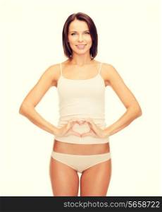 health, pregnancy and beauty concept - beautiful woman in cotton underwear forming heart shape