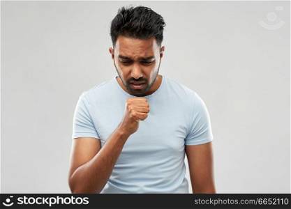 health problem and people concept - unhealthy indian man coughing over grey background. unhealthy indian man coughing