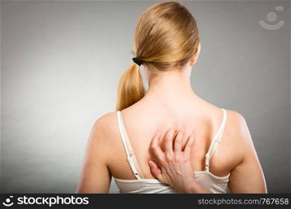 Health problem, skin diseases. Young woman scratching her itchy back with allergy rash. woman scratching her itchy back with allergy rash