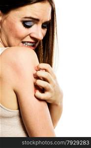 Health problem. Young woman scratching her itchy arm with allergy rash