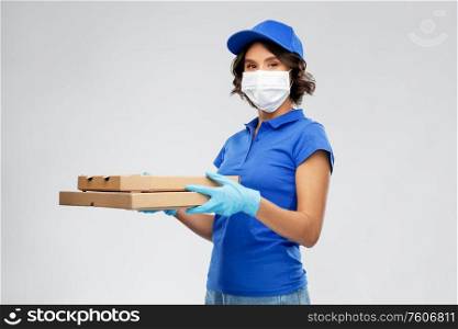 health protection, safety and pandemic concept - delivery woman in face mask and gloves with pizza boxes over grey background. delivery woman in face mask with pizza boxes