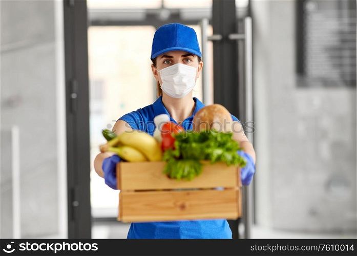 health protection, safety and pandemic concept - delivery woman in face mask and gloves holding wooden box with food. delivery woman in face mask with food in box